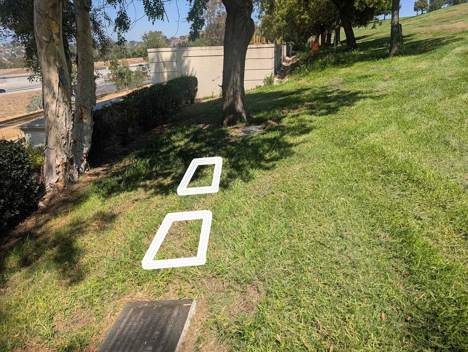 Two burial plot outlines on the grass